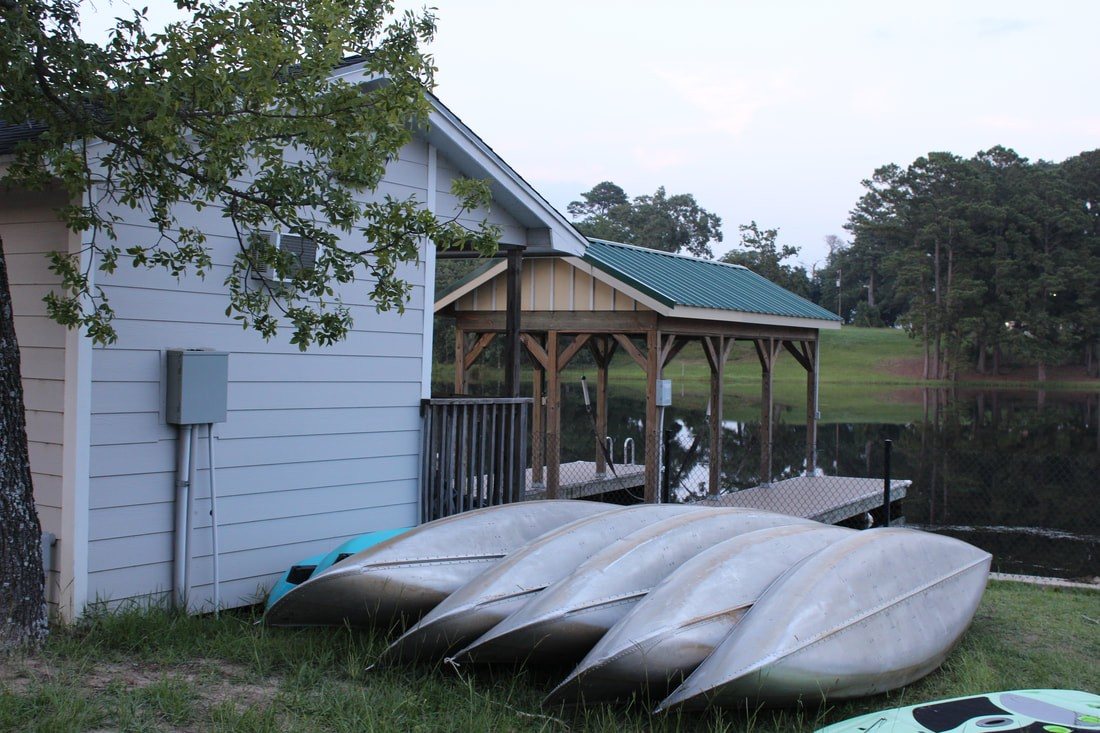 Canoes lined up by the boathouse at Lone Star Camp